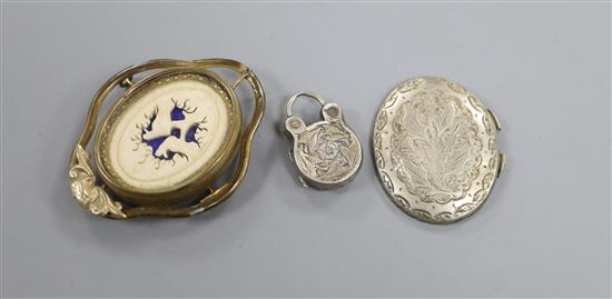 A Victorian gilt metal mourning brooch, inset an ivory panel carved with ghostly features, vacant glazed back and an enclosed locket